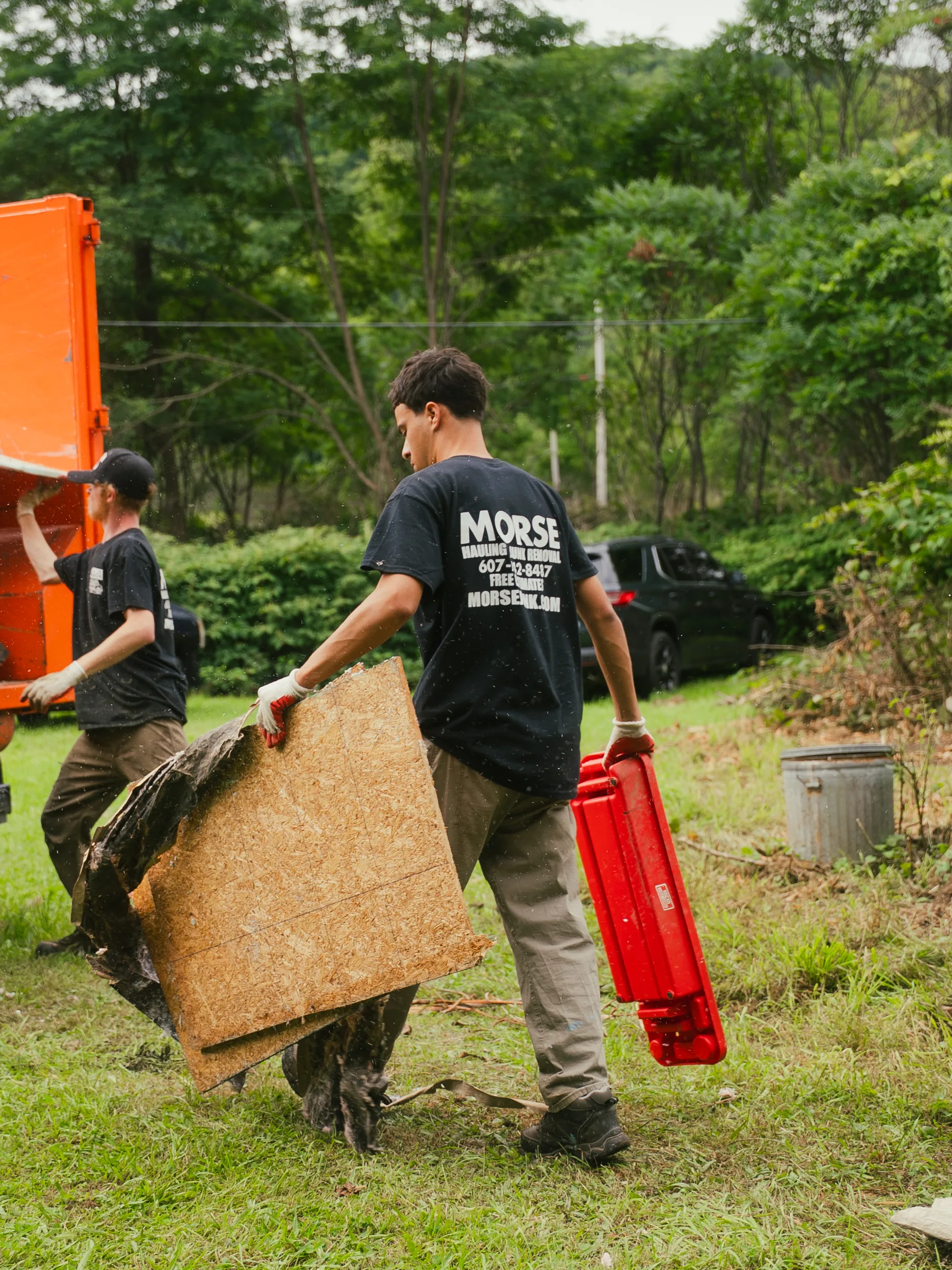 Morse Dumpsters team hauling debris to an orange roll-off dumpster, Horseheads NY